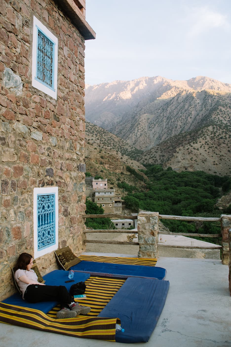 Sarah relaxing on a balcony with mountains in the background