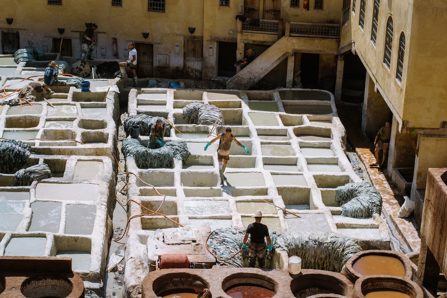 A man working in an open air leather tannery.