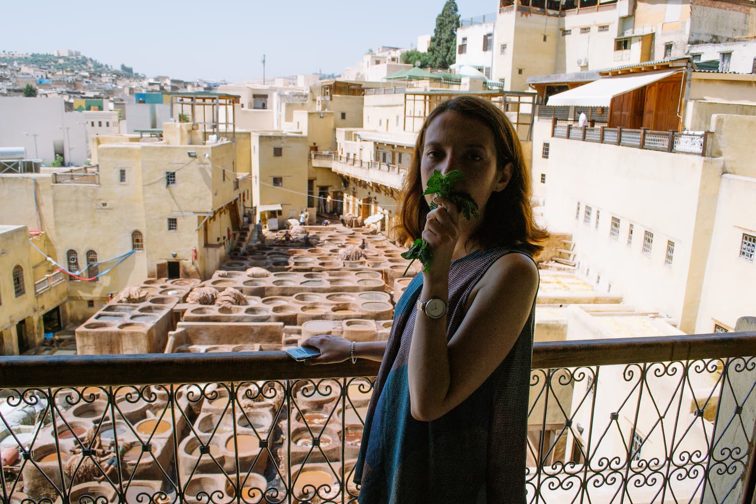 Sarah holds mint to her nose while looking out over the tannery