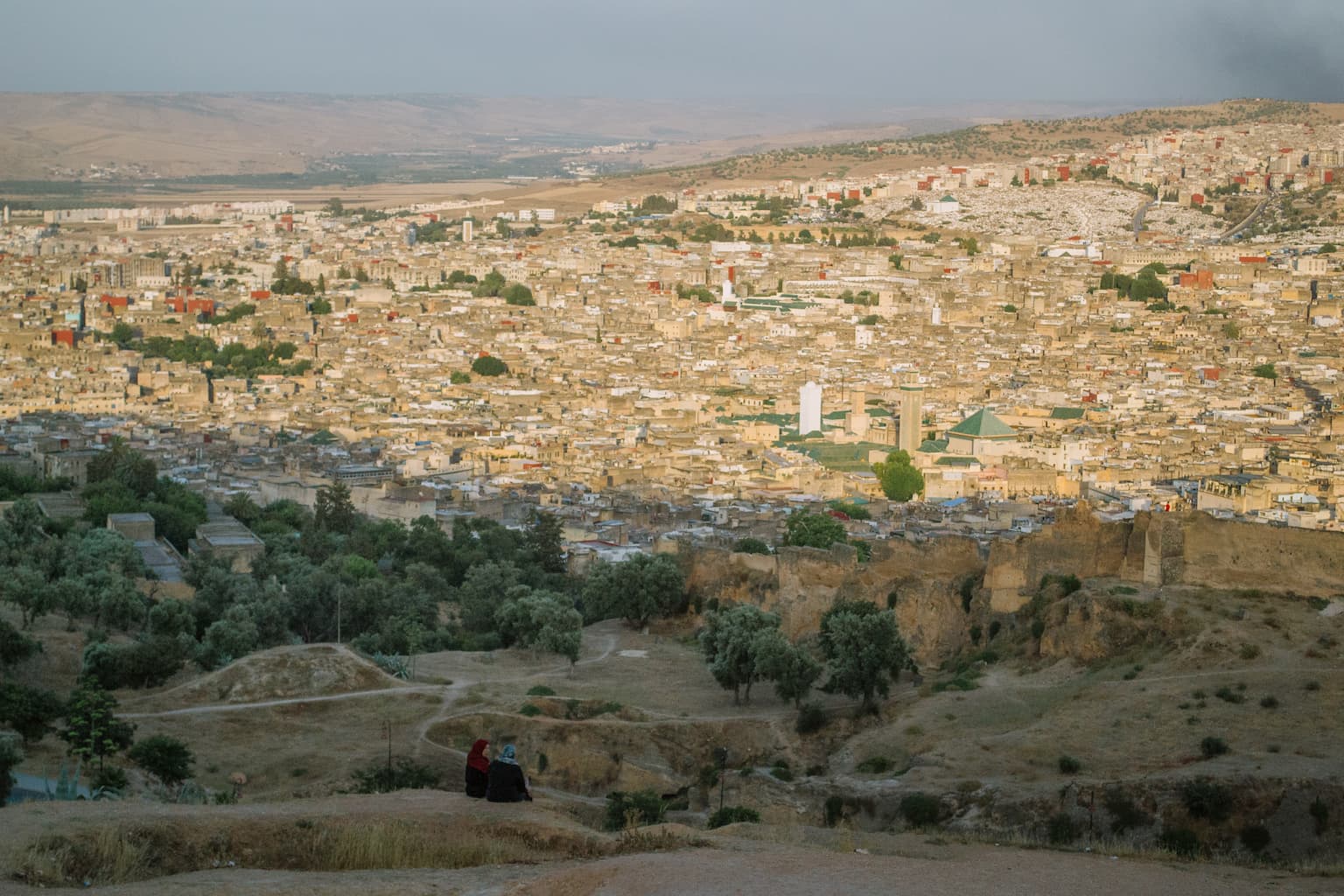 Two women look out over Fez at sunset