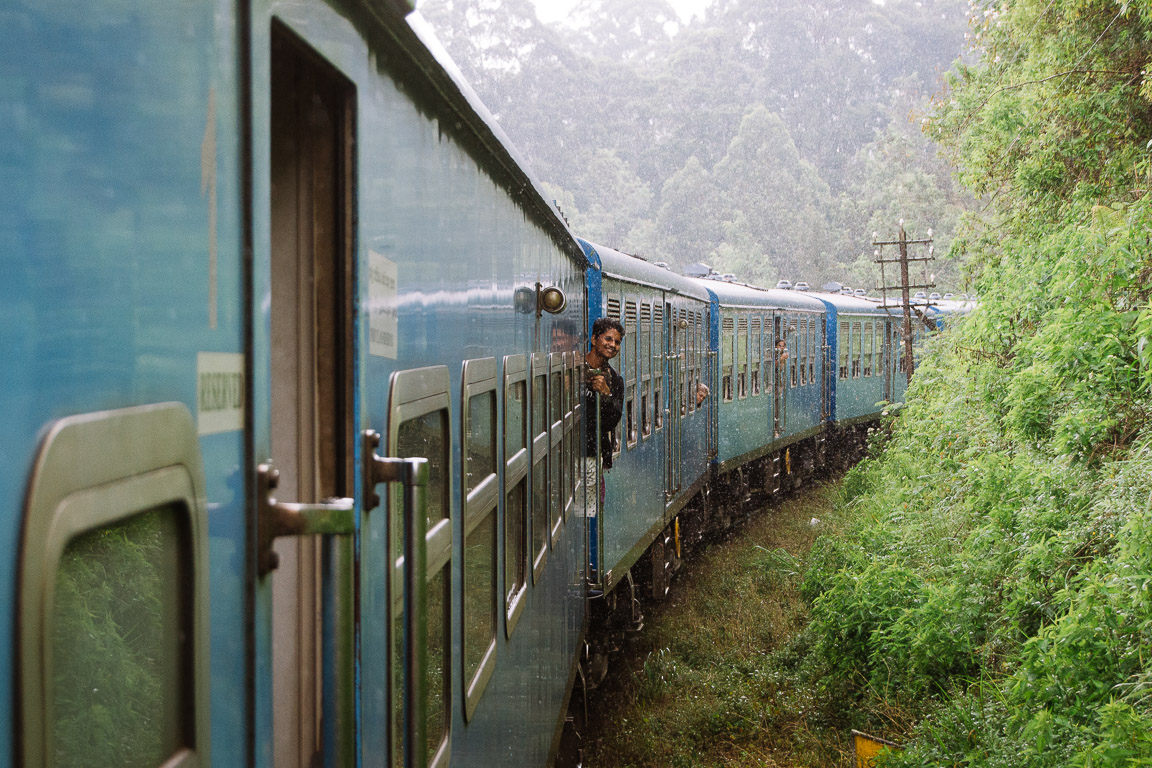 Blue train moving through forest