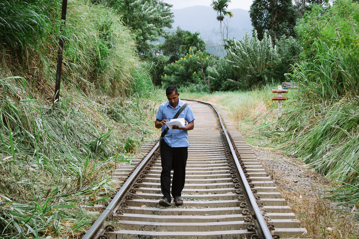 Postman walking along train tracks