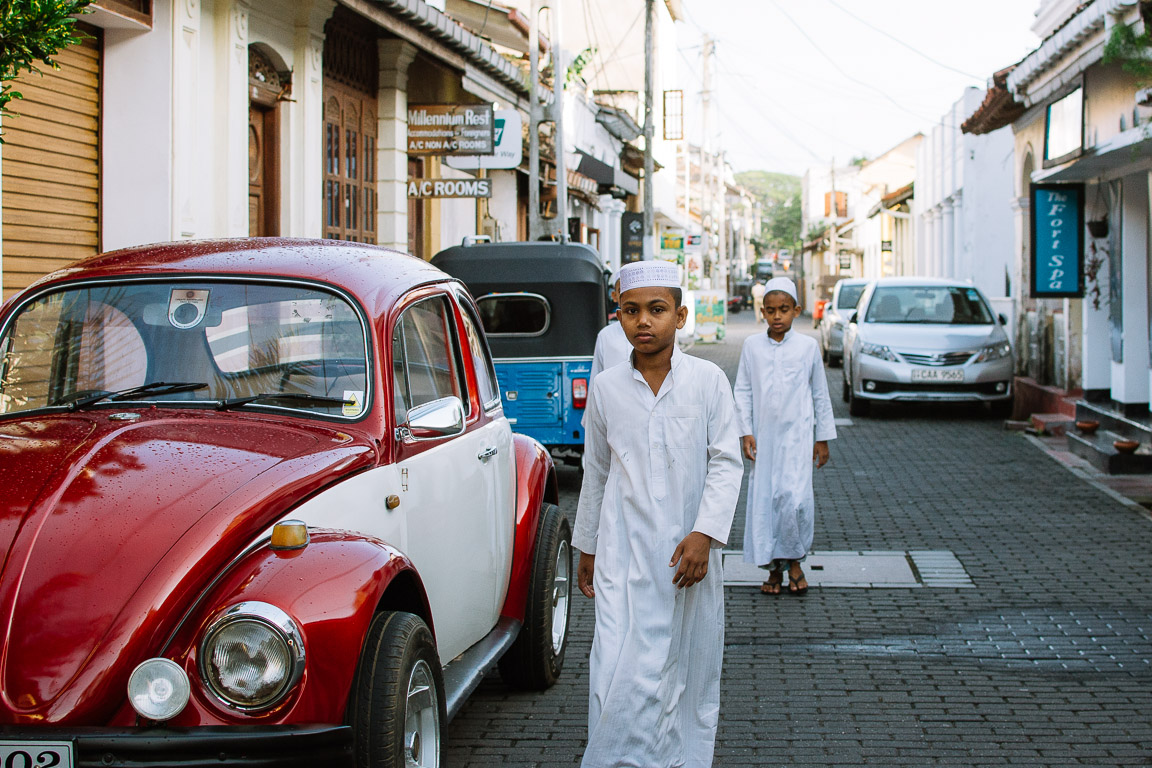 Sri lankan boys next to a vintage car