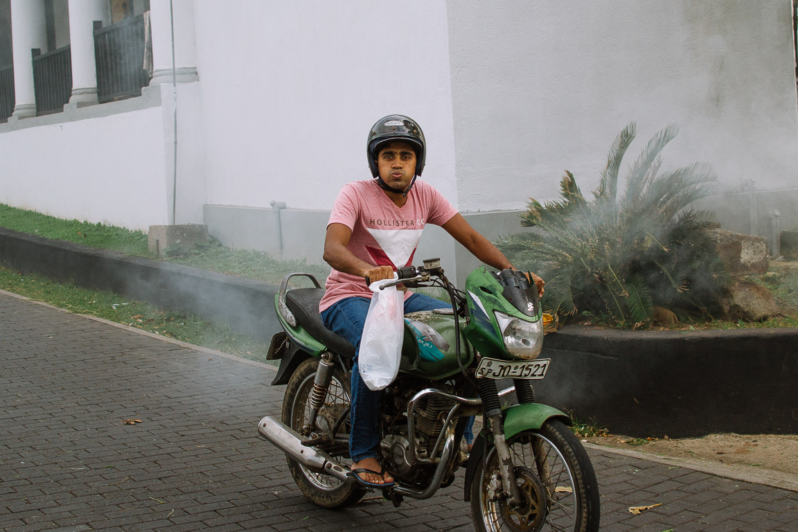 A sri lankan man on a motorbike